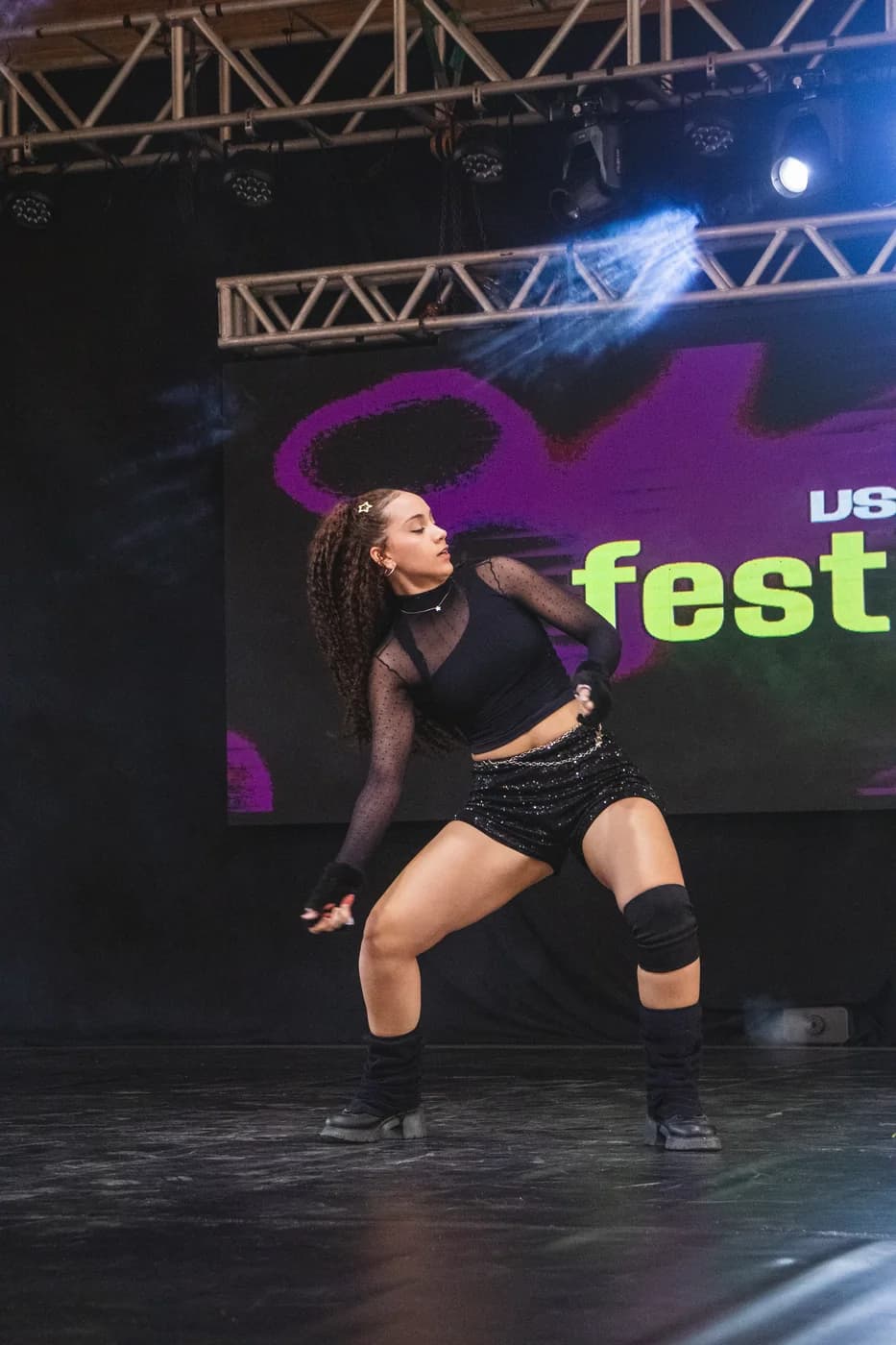 Bailarina solo de dança urbana em pose de força no palco da Usualdance Festival 2026